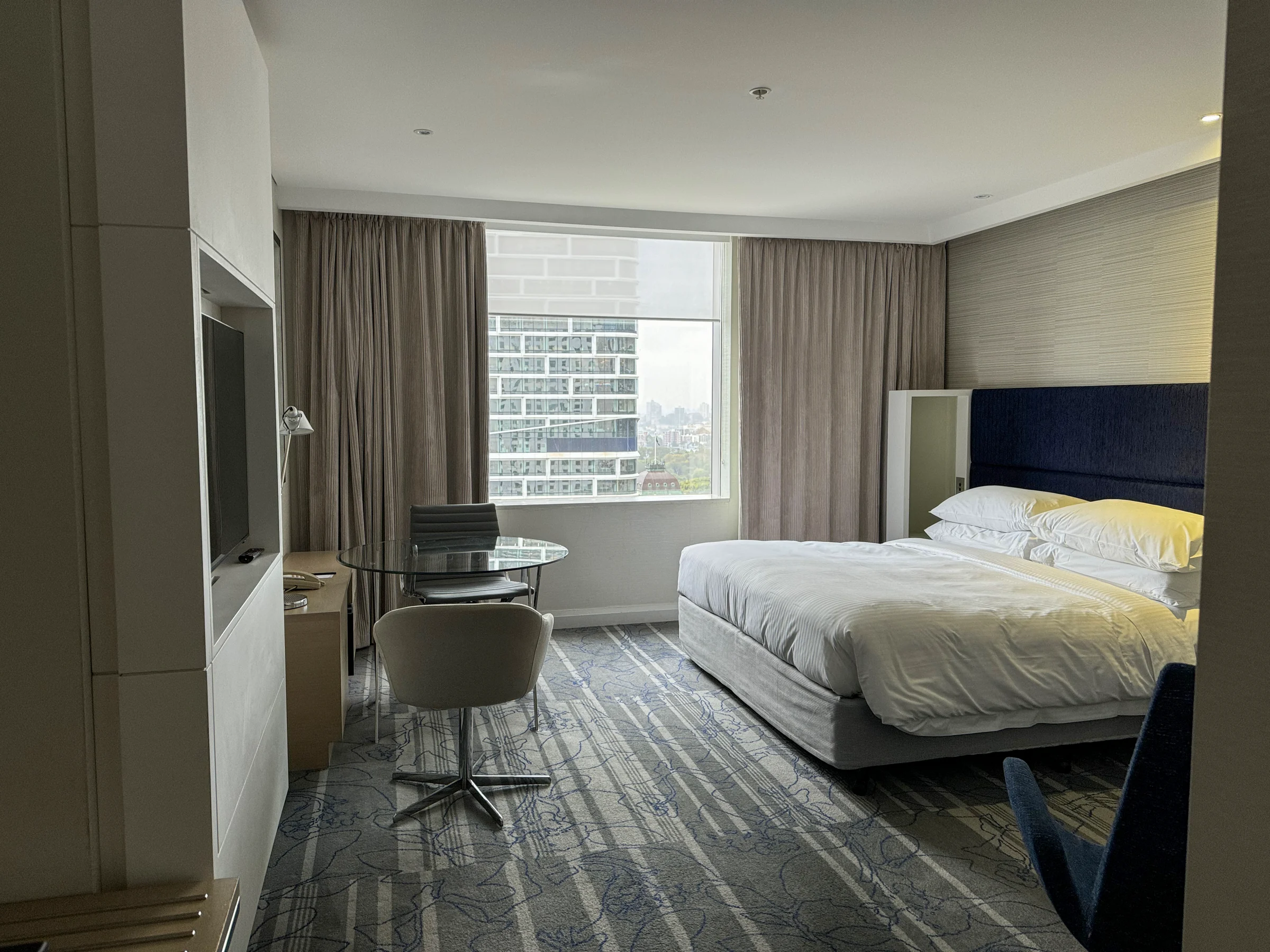 The king bed and chairs by the window.