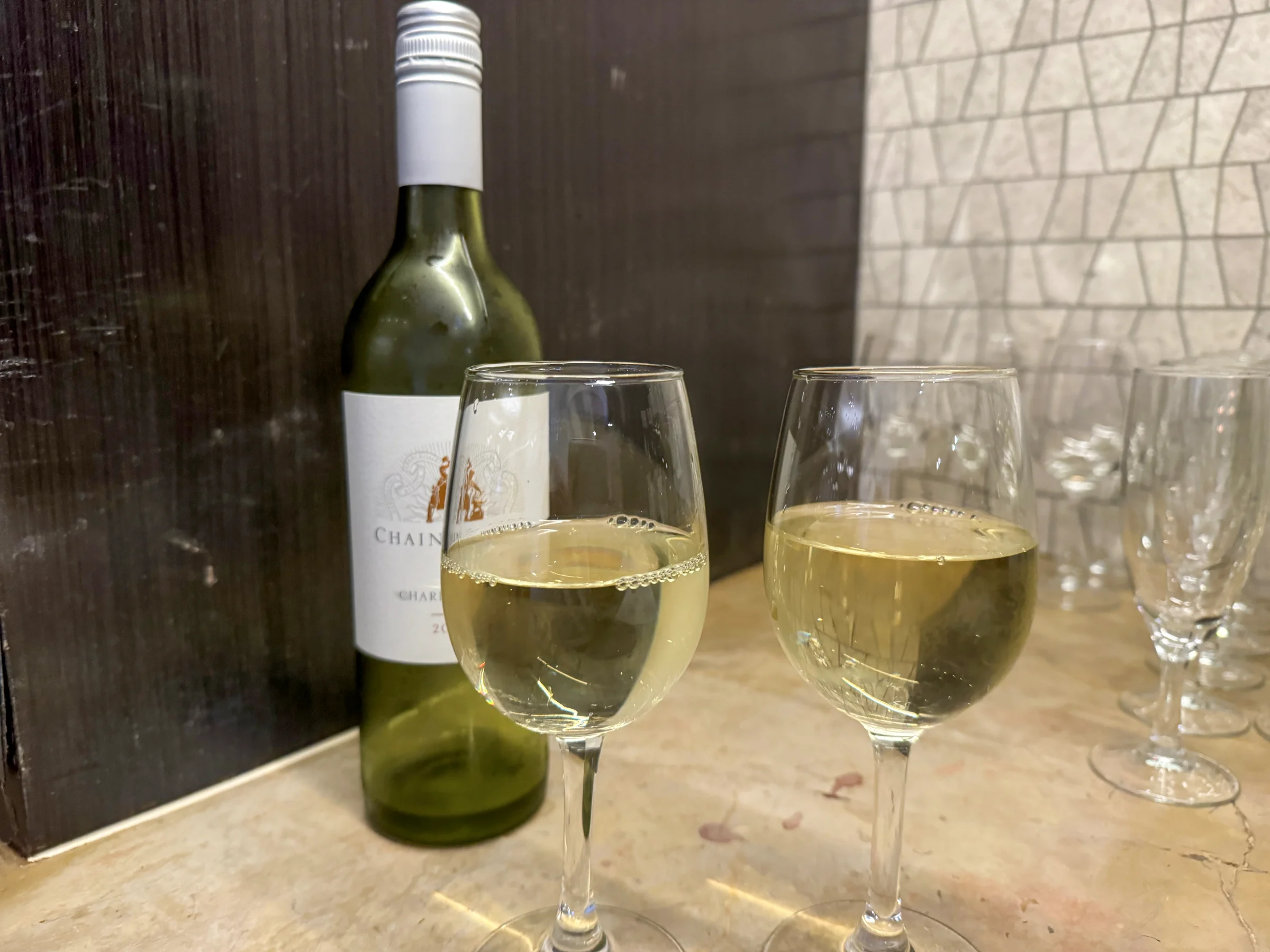 A glass of wine at a table by the window.