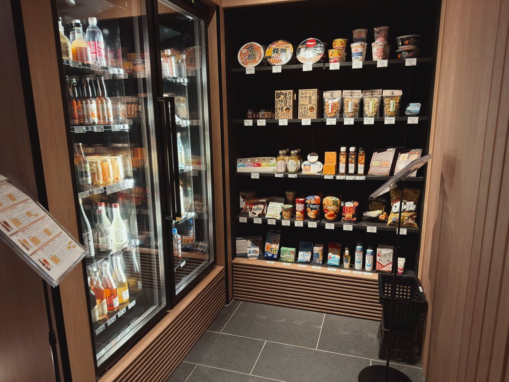 フェアフィールド・バイ・マリオット 京都京丹波のレセプション横にある売店。冷蔵庫には飲み物や軽食、棚にはカップ麺やお菓子、ドリンクなどが並んでいます。