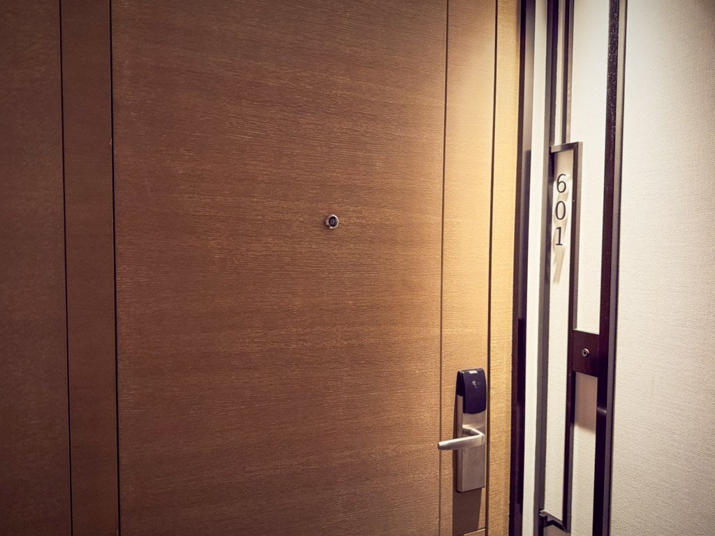  フォーポイントバイシェラトン香港、東涌の601号室のドア。木目調のドアにシンプルなデザインのルームナンバーが配置されている。 