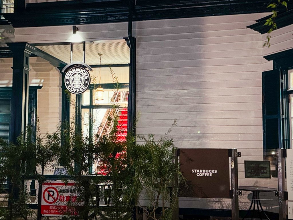 ホテル近くのおしゃれなスターバックスの外観。クラシックな建物にスターバックスのロゴが目立ち、ライトアップされた雰囲気が印象的です。