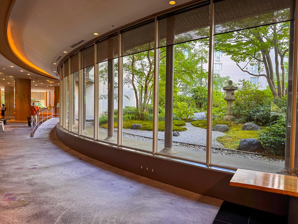  このホテルは、独特な円形のデザインが特徴です。建物は円を描くように配置されており、その中央には美しい庭が広がっています。庭は四季折々の自然を楽しめるよう設計されており、客室や共用スペースからもその風景を楽しむことができます。 
