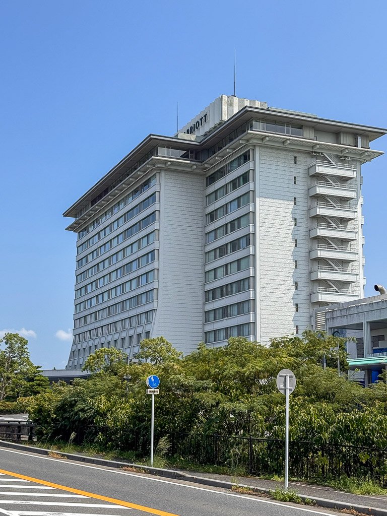 今まで泊まったマリオットホテル全体に言えることですが、少し古びた外観が目立ちます。今回は堅田駅から出ている無料のシャトルを利用する予定でしたが、JRの遅れでシャトルの時間に間に合いませんでした😭 シャトルは1時間に一本しかないため、琵琶湖マリオットに車で行かない場合は、事前に時間をしっかり調整することをお勧めします。驚いたことに、Uberが使えなかったため、最寄りのバス停から猛暑の中を約25分歩くことになりました。