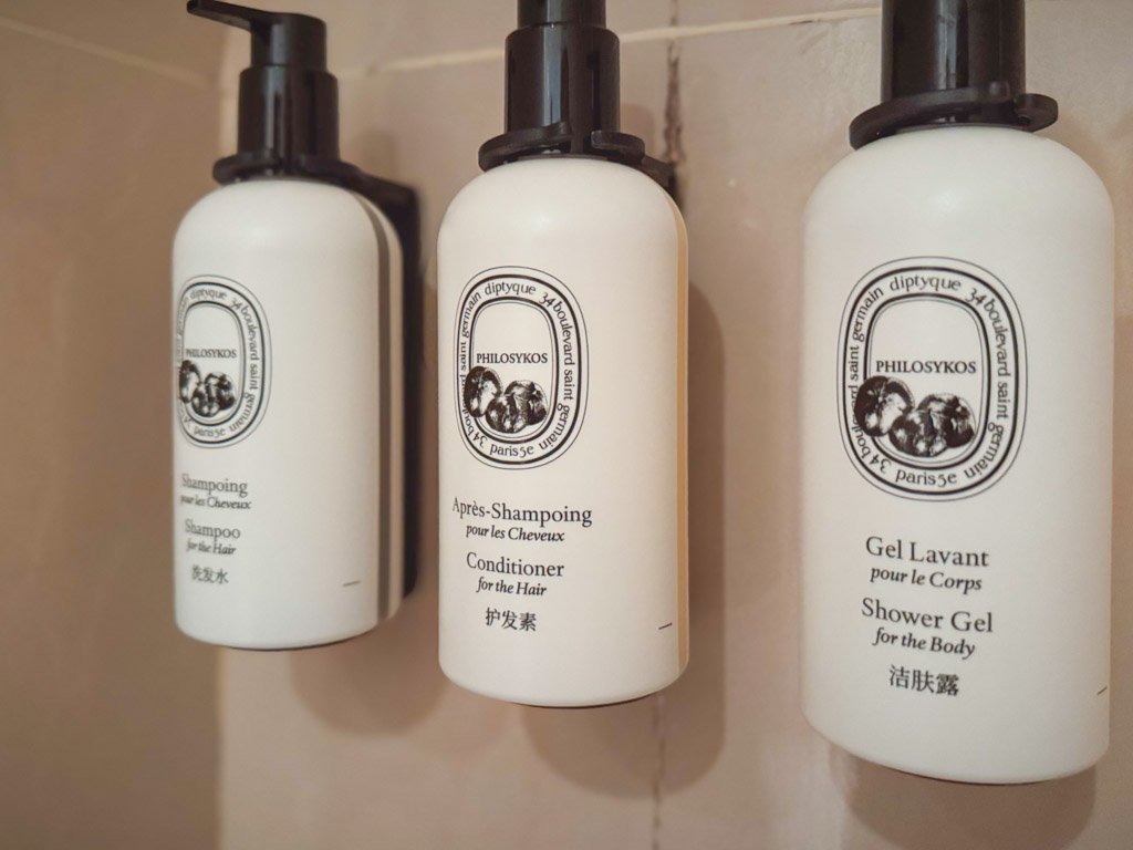  バスルームに備え付けられたディプティック（Diptyque）の高級バスアメニティ。シャンプー、コンディショナー、シャワージェルの3種類が用意されており、統一感のあるデザインボトルが並んでいます。上品でラグジュアリーな雰囲気を演出しています。 