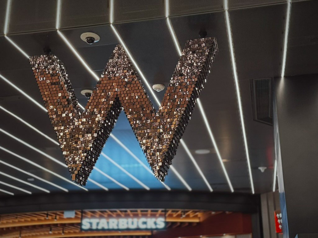  スタジオシティ内、Wホテルのロゴが輝くエントランスエリア。奥にはホテルの入り口が続き、モダンで豪華な雰囲気が広がっています。 