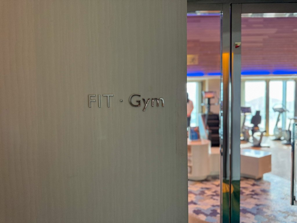  「FIT・Gym」と書かれたサインとジム内部の様子が見えるドア。 