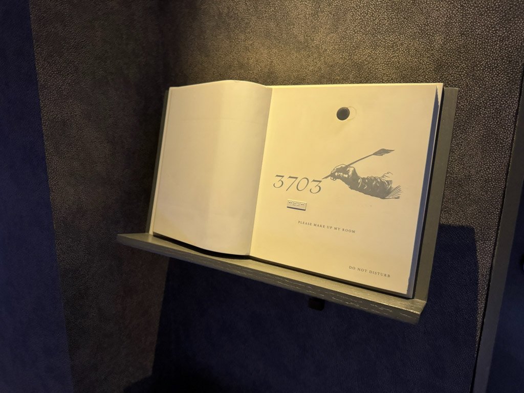  W香港の客室ドア前に設置されたルームナンバープレート。オープンブックのデザインで「3703」と部屋番号が記され、「PLEASE MAKE UP MY ROOM」と「DO NOT DISTURB」のメッセージが表示されている。 