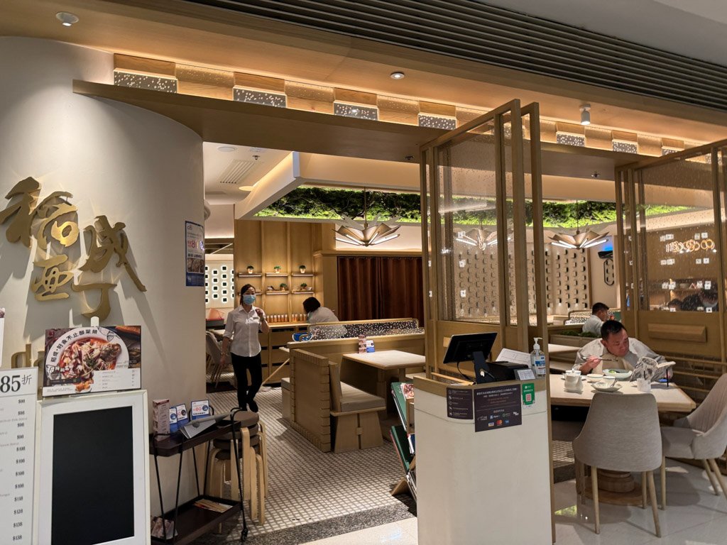  W香港の館内にあるレストランの一角で、モダンで落ち着いた内装が特徴的です。スタッフやお客さんが食事を楽しんでいる様子が見られます。 