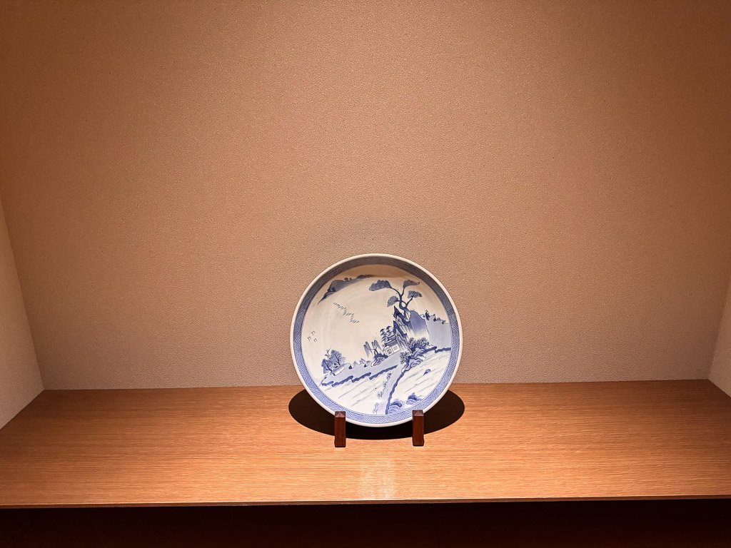  紫翠の客室内に飾られた大きな青い絵皿  Large blue decorative plate displayed in a guest room at Shisui 