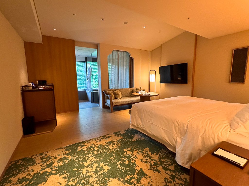  紫翠のデラックスキングルーム 室内のベッドとソファエリア  Deluxe King Room at Shisui with bed and sofa area 