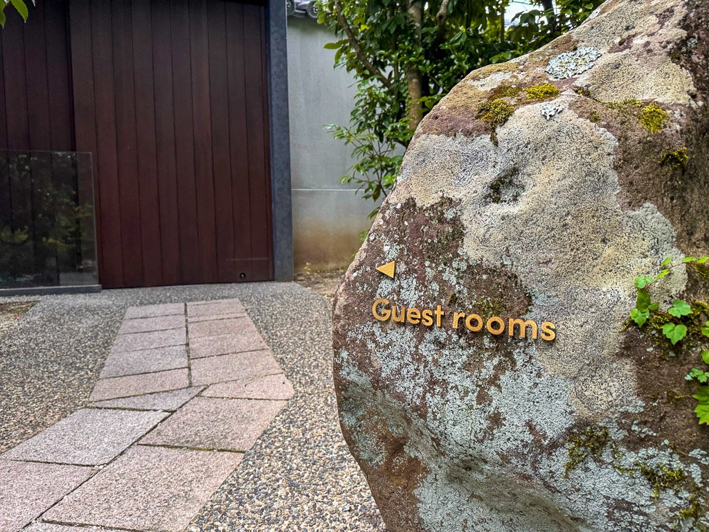  紫翠のゲストルームへの案内を示す苔むした石のサイン  Moss-covered stone sign pointing to the guest rooms in Shisui 
