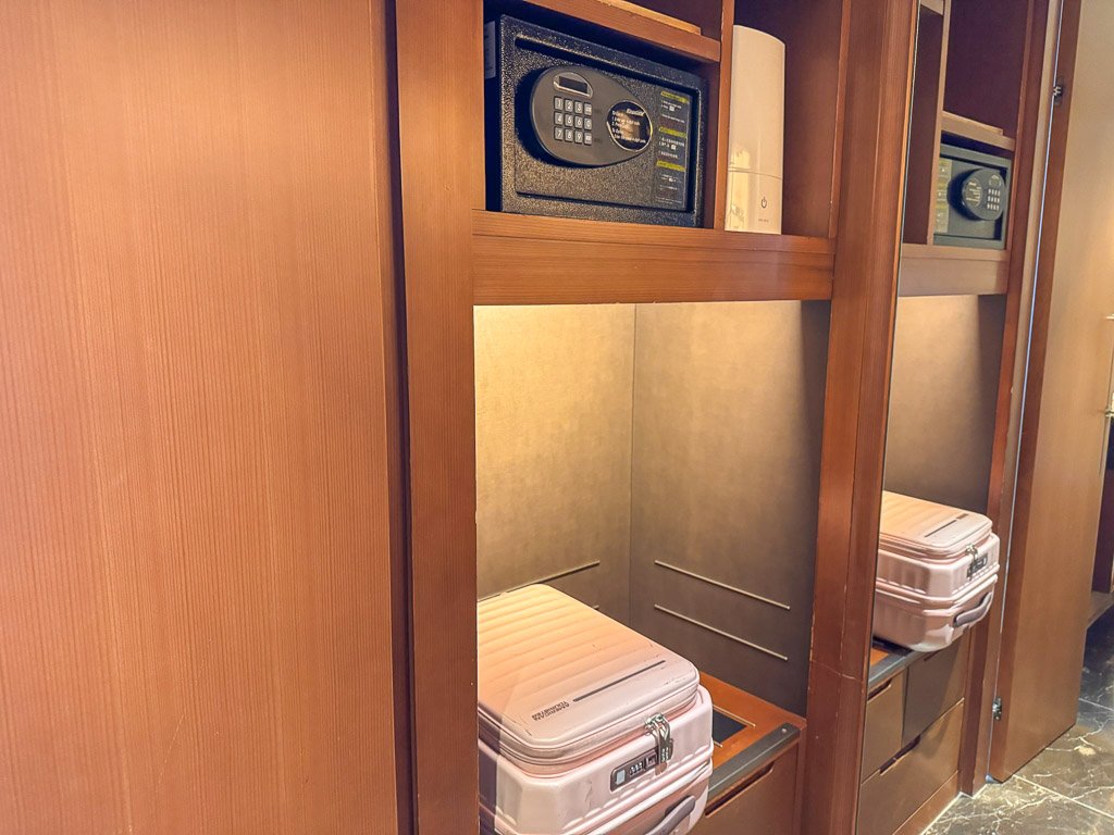  セントレジス大阪の広々としたクローゼットには、安全なセーフと十分な荷物収納スペースがあります。バトラーが丁寧に荷物を整理してくれるので、安心して過ごせます。  A glimpse inside the spacious closet at The St. Regis Osaka, featuring a secure safe and ample storage space for luggage. The attentive butler places your belongings neatly, ensuring everything is in order.  