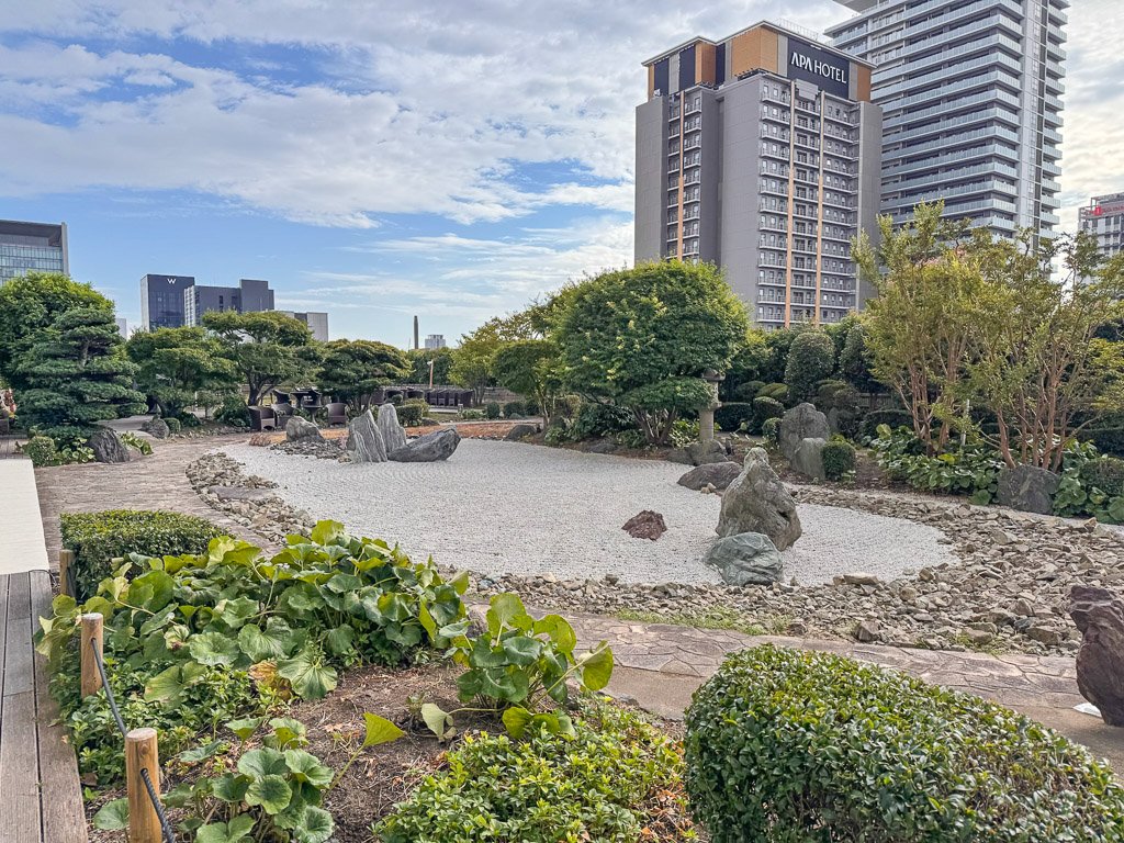  セントレジス大阪のセントレジスバーからは、日本庭園「天空の庭」を眺めることができます。庭の中央には、2匹の竜が巴型に交差する枯山水があり、「交龍の庭」と名付けられています。  A view from The St. Regis Bar at The St. Regis Osaka, overlooking the Japanese ‘Tenku no Niwa’ (Sky Garden) with its central Karesansui design, depicting two intertwining dragons in a Tomoe pattern, known as ‘Koryu no Niwa’ (Garden of Intertwining Dragons). 