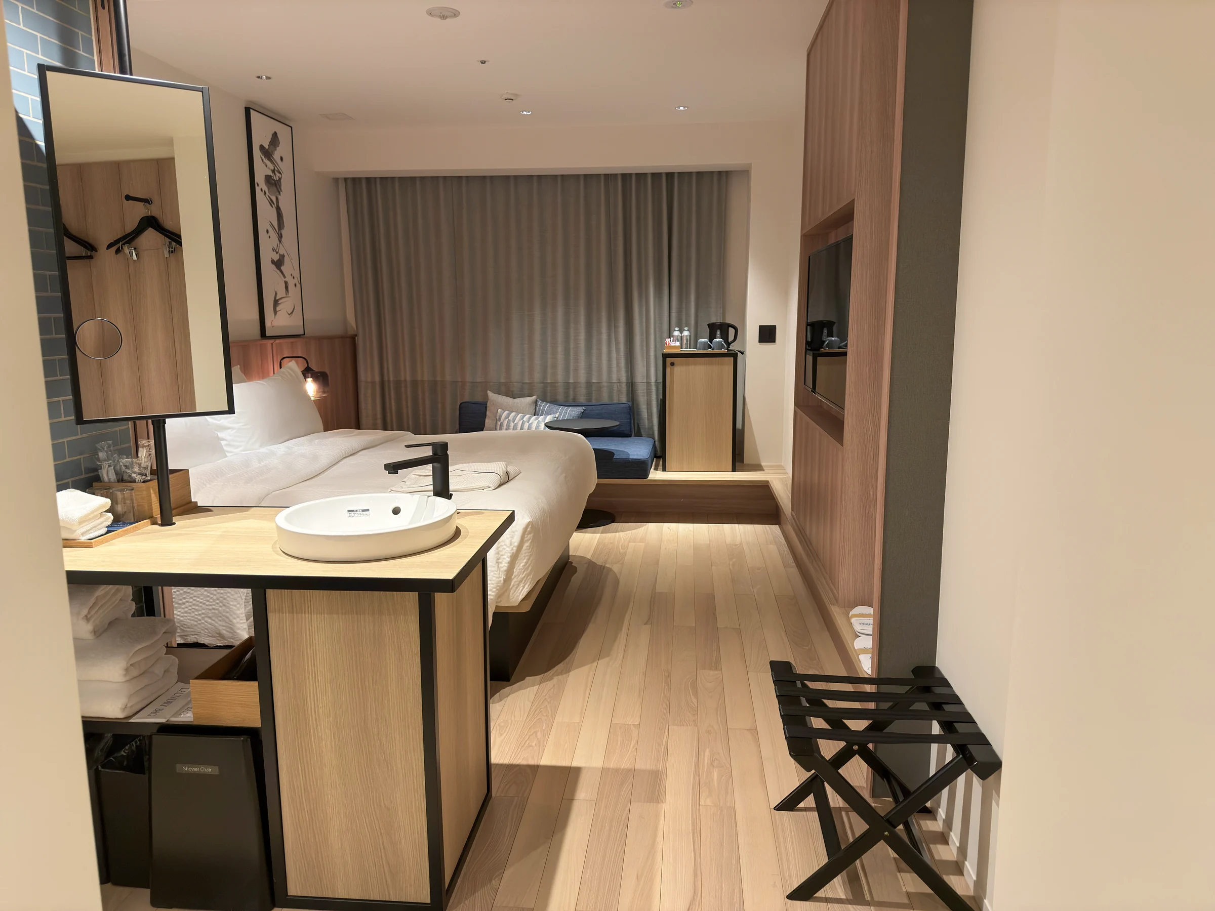 The Kyoto Kyotamba room with a king bed, wood-effect flooring and a blue sofa