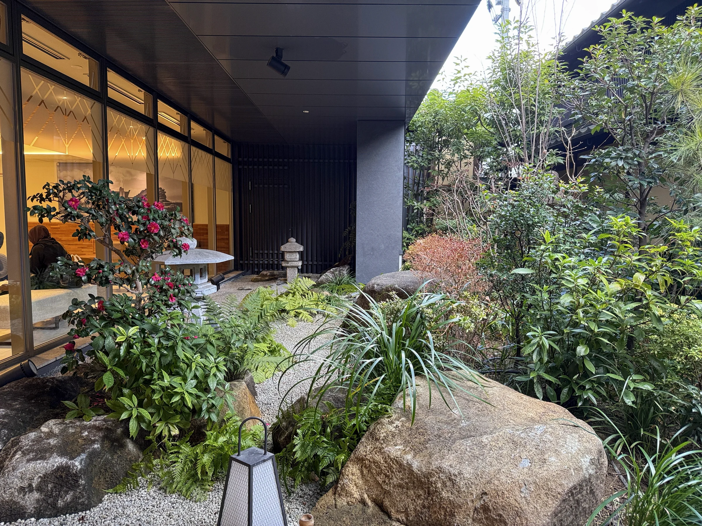 A garden with greenery and a stone lantern.