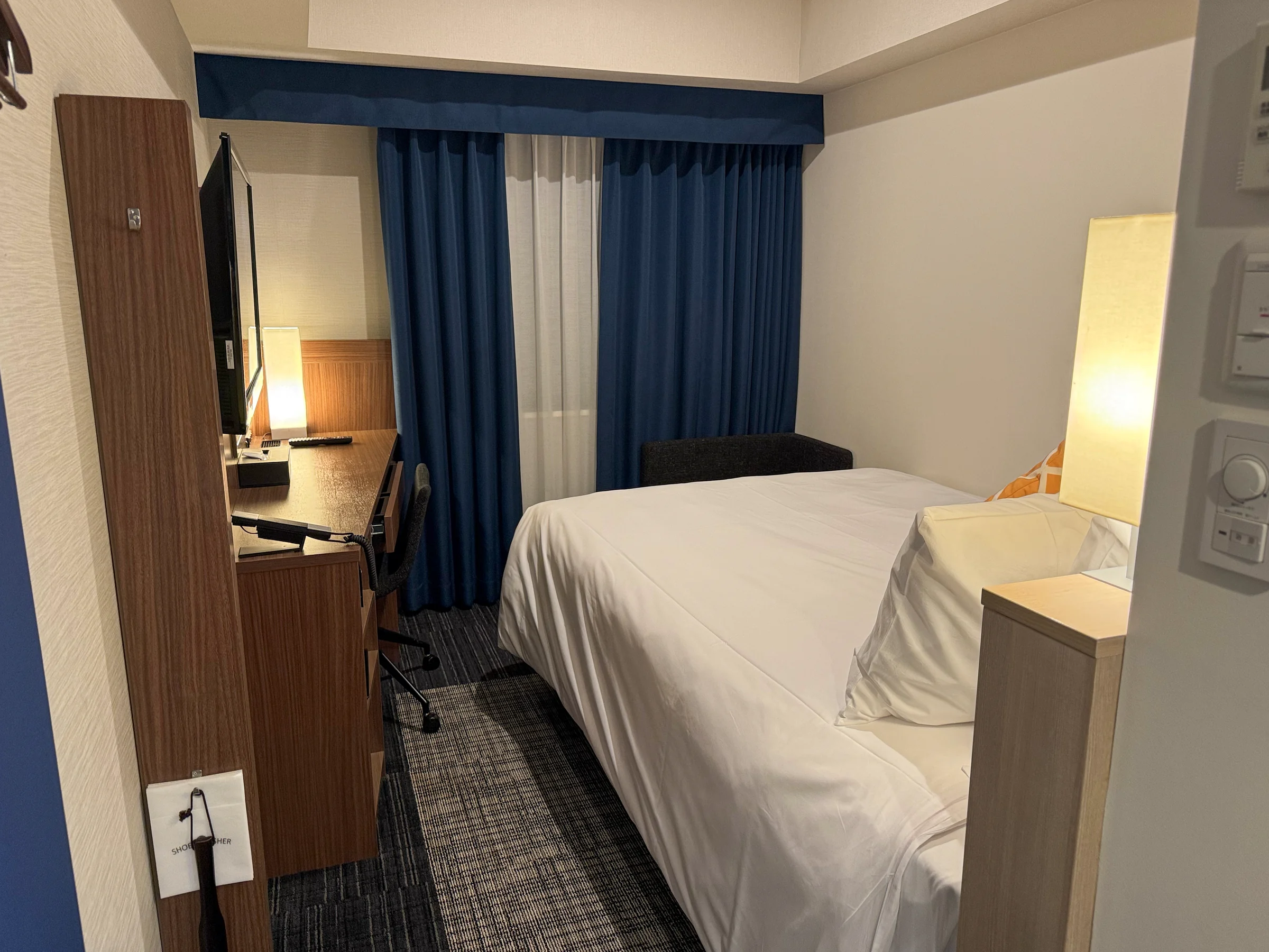 A room with blue curtains and a double bed at Four Points Flex Yokohama West