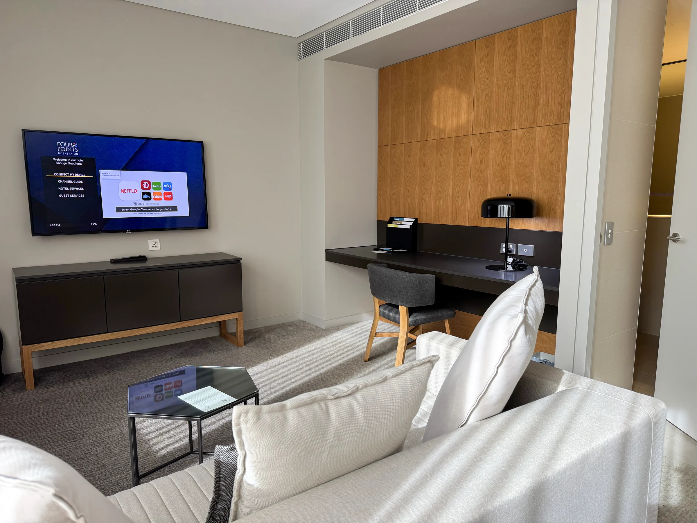 A television and desk opposite the sofa.