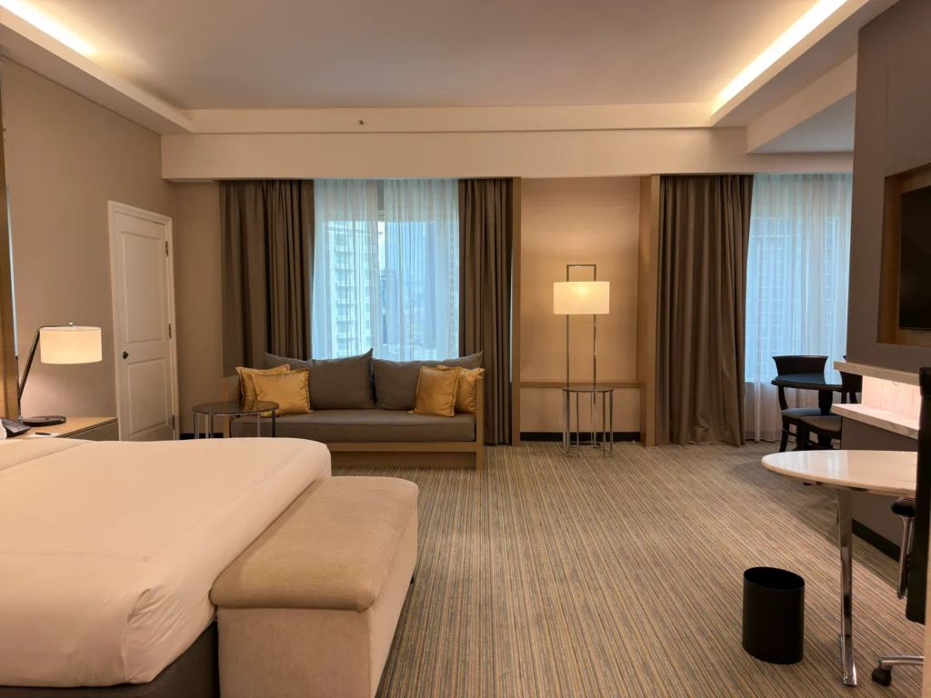 JW Marriott Hotel Kuala Lumpurのスタジオスイート、キングベッドと窓辺のソファ