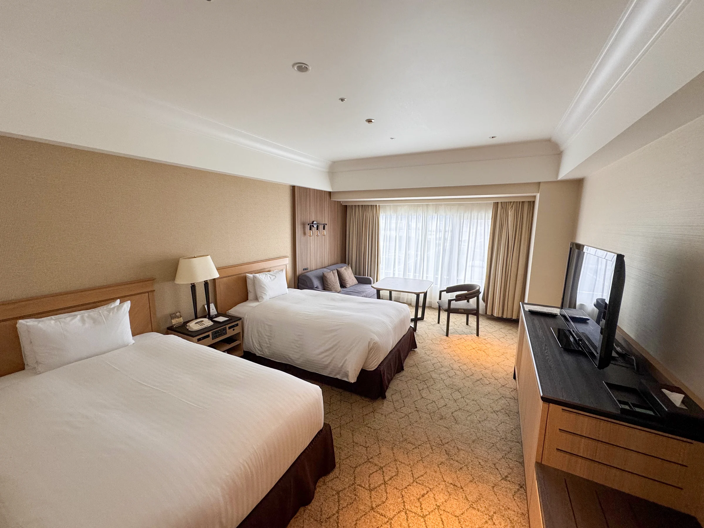 Twin beds and a sitting area by the window.