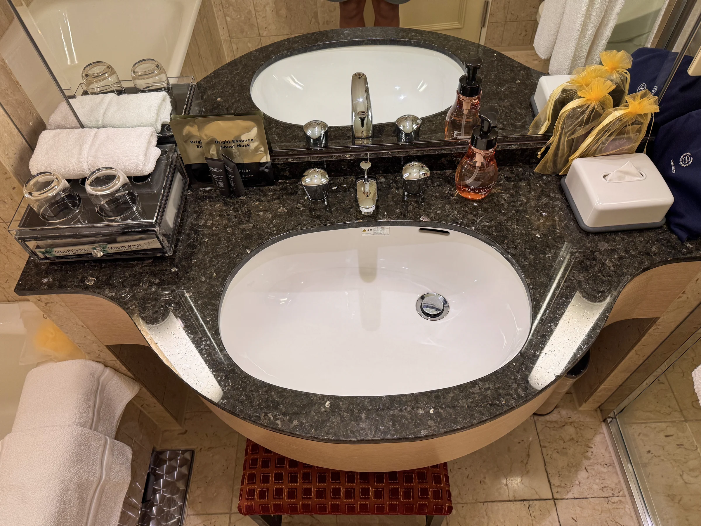 A washbasin with a black countertop.