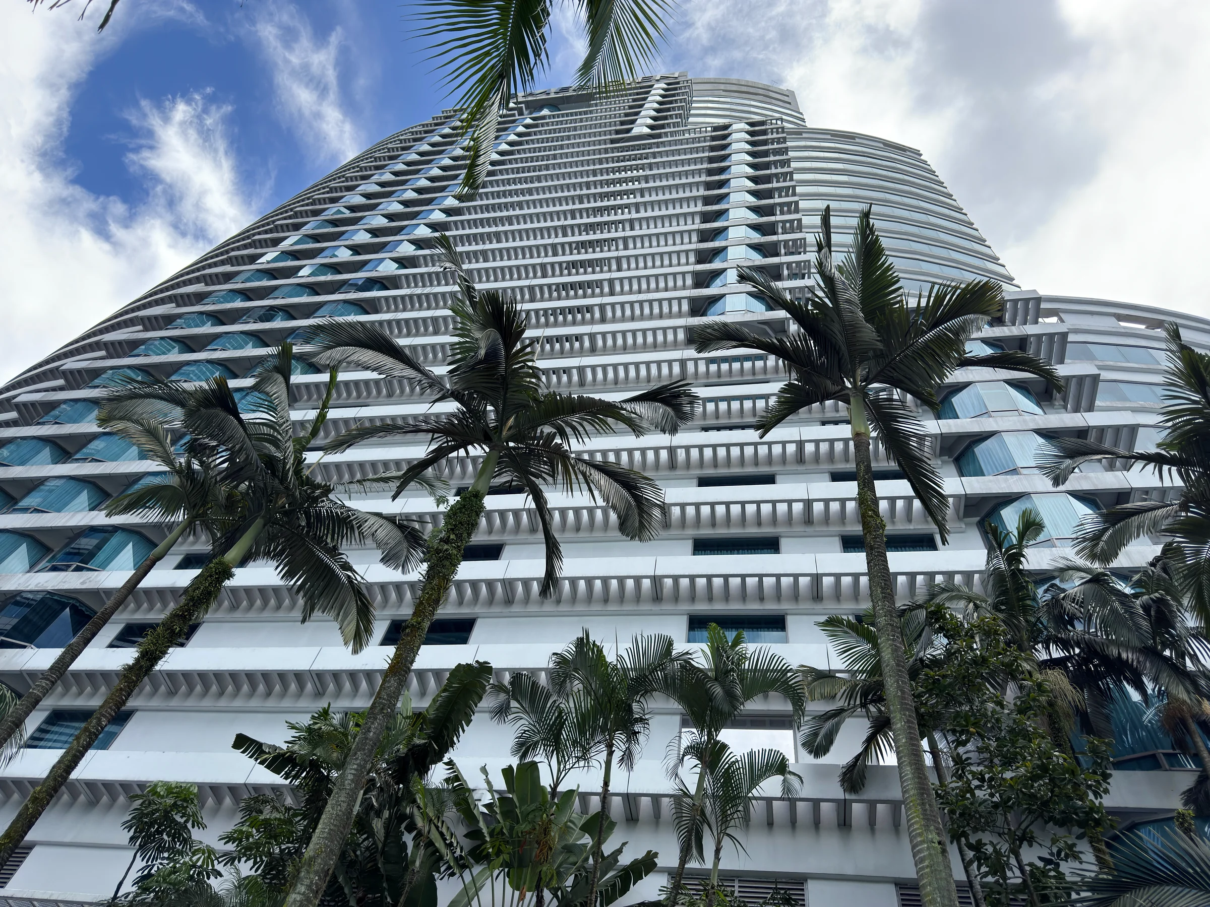 Looking up at the hotel through palm trees.