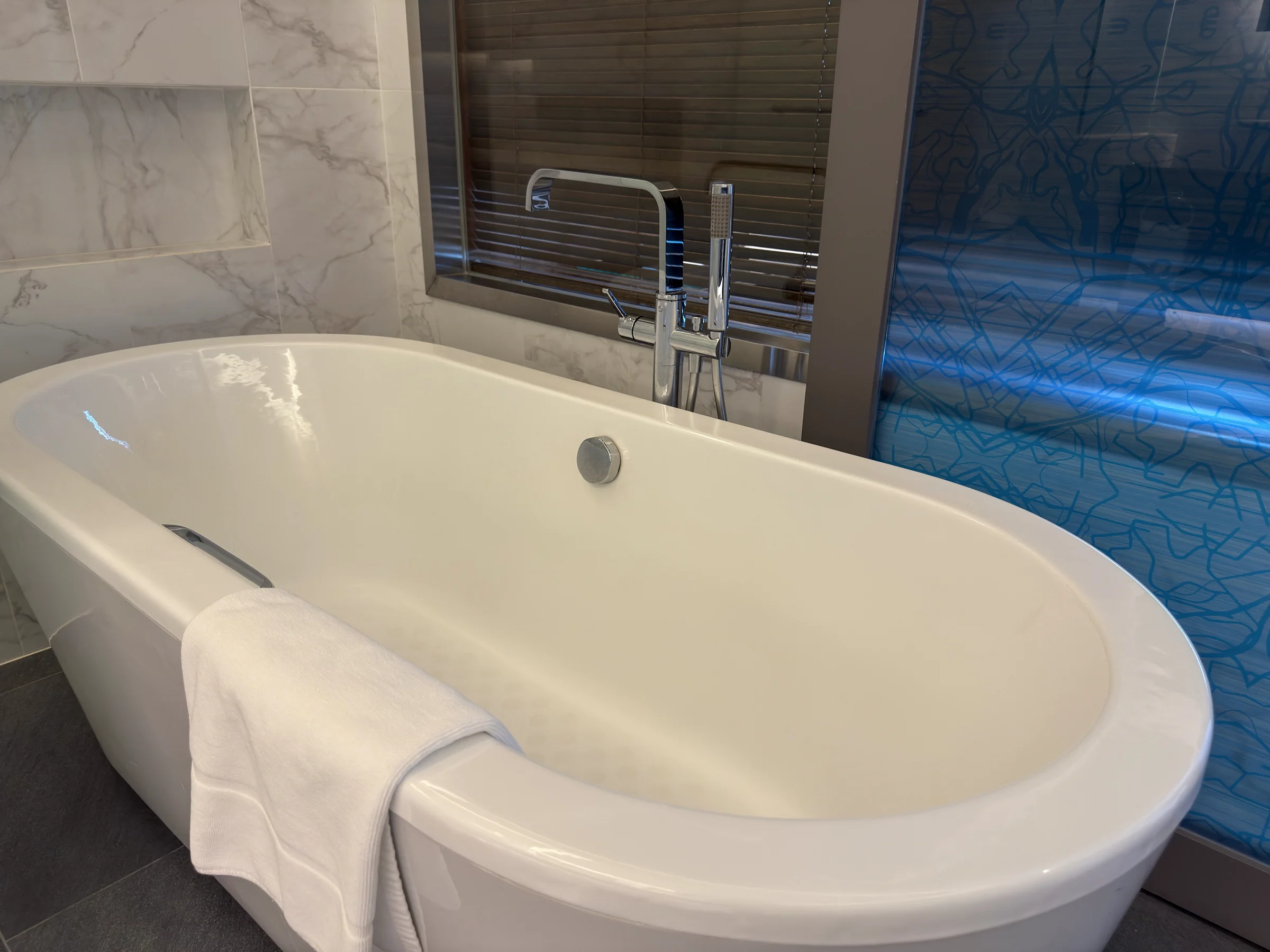The bathtub by the window.