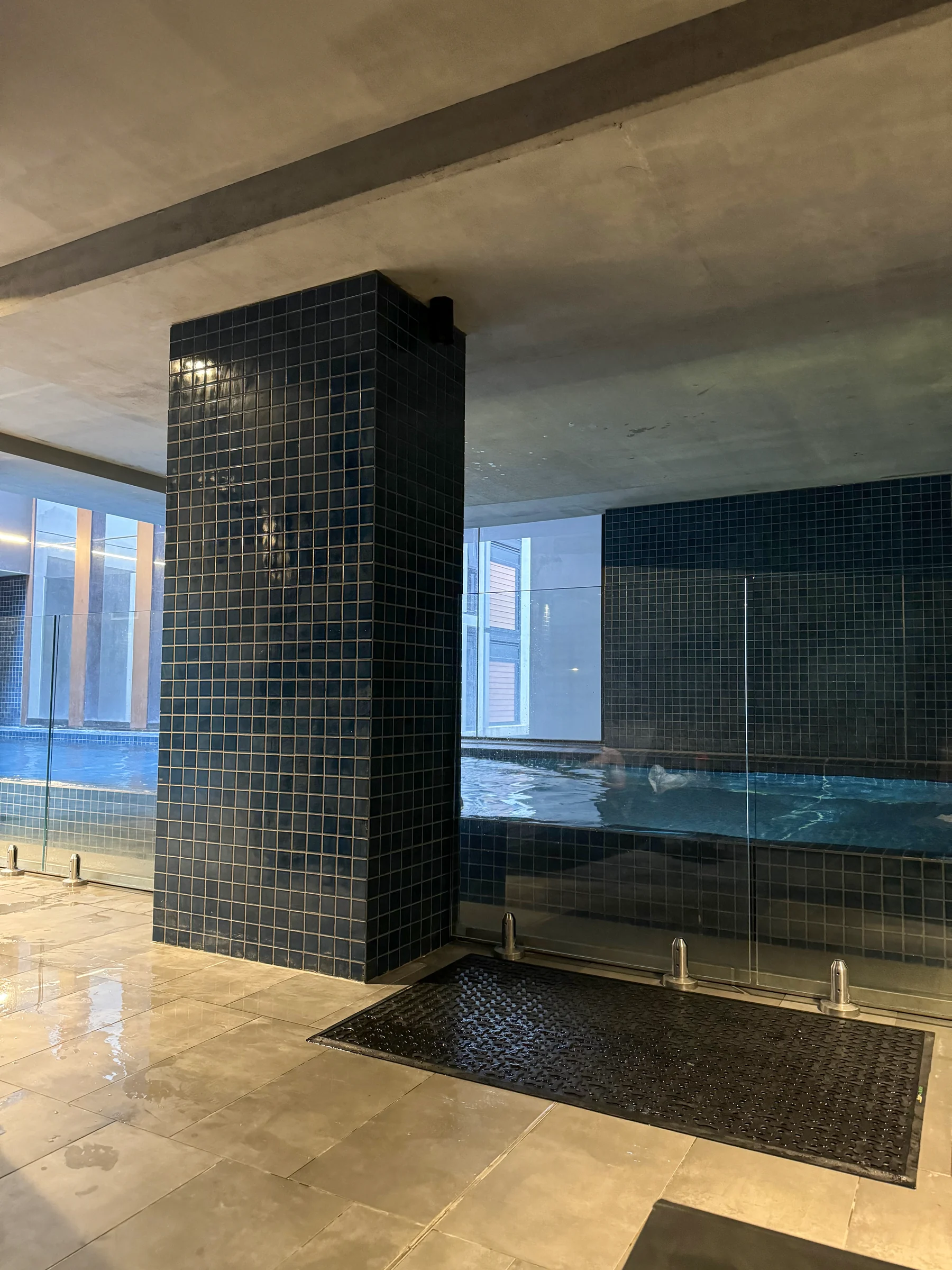 Black tiled walls beside the pool.