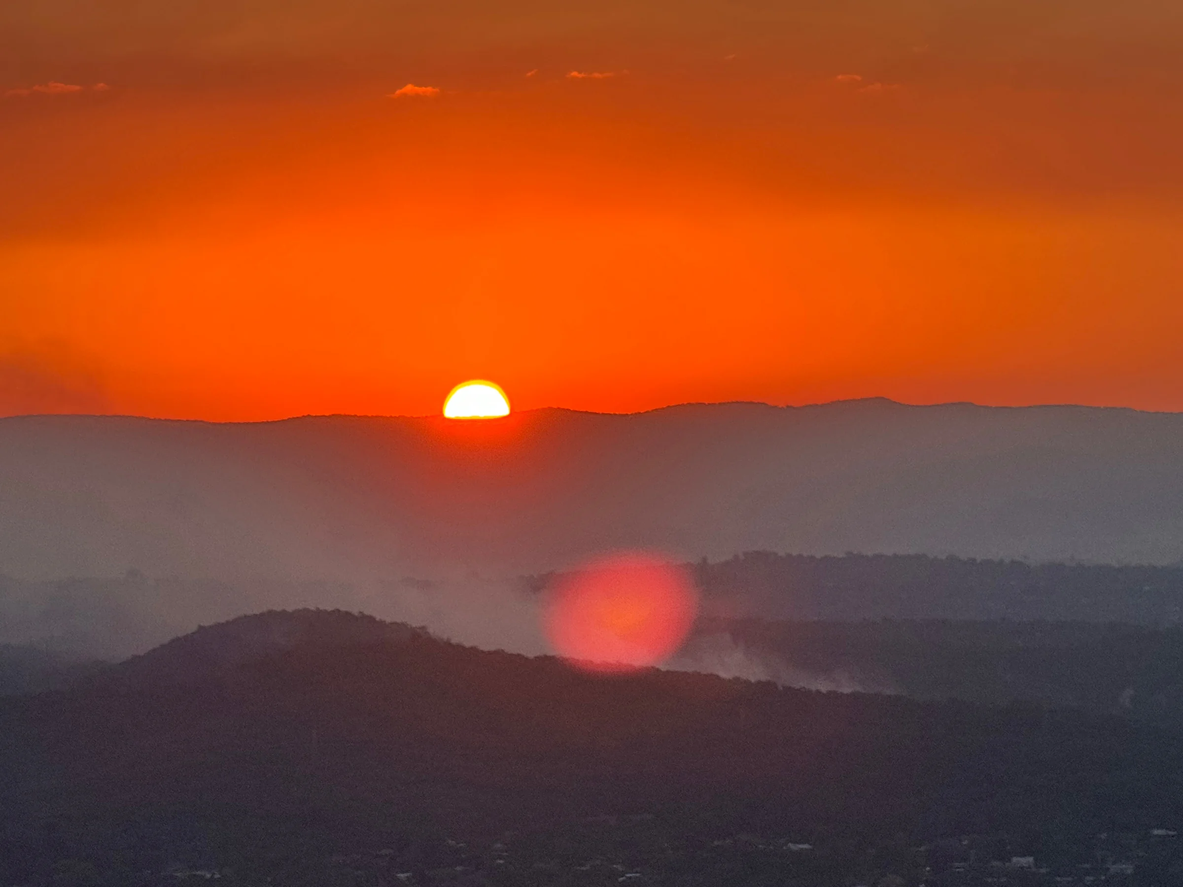 The sun setting beyond the hills.