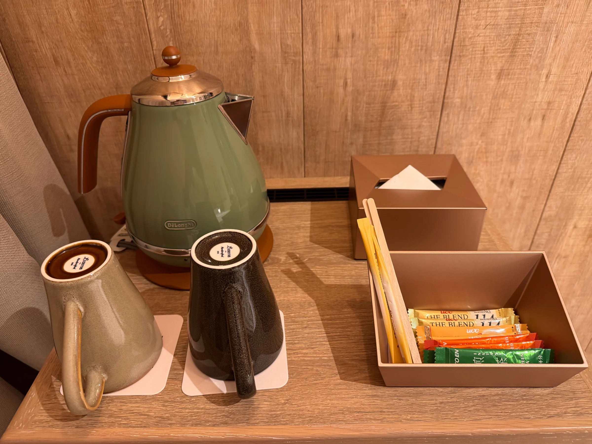 A kettle and tea set on a wooden shelf
