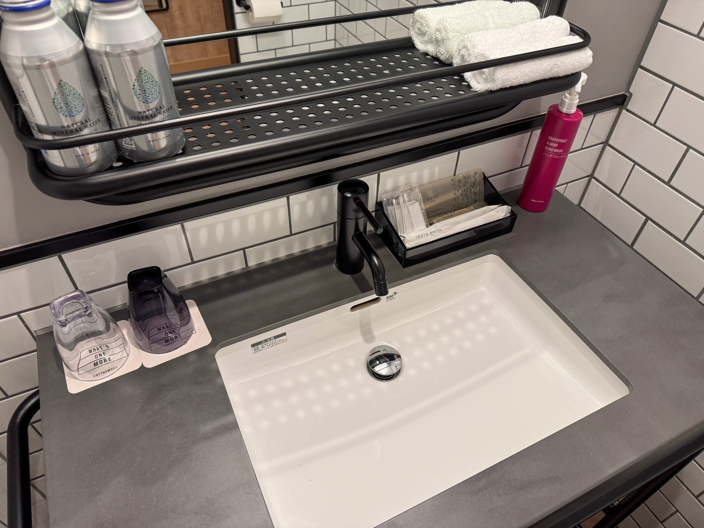 The vanity with white tiles and black fittings