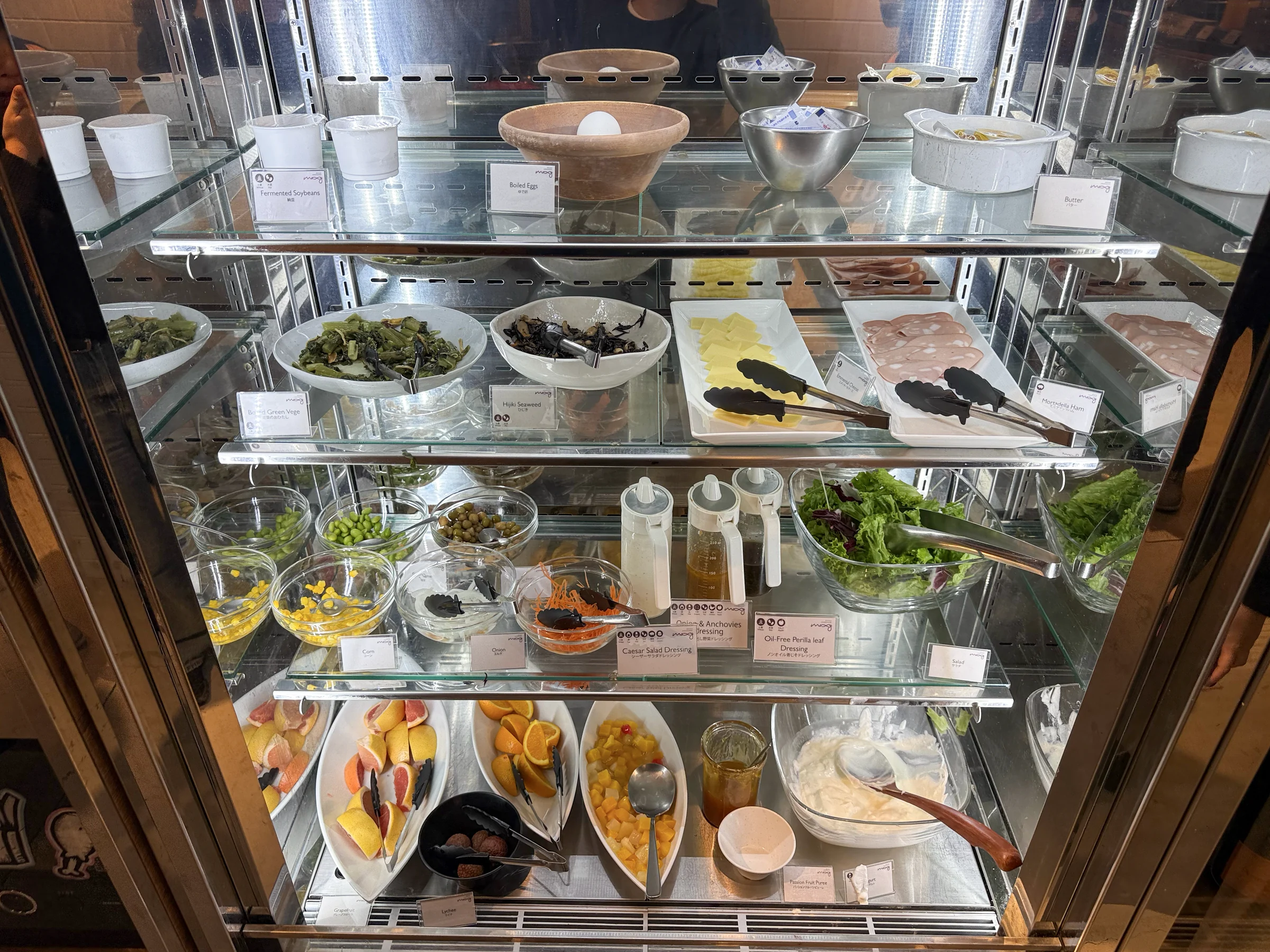 The refrigerated display with salads and fruit.