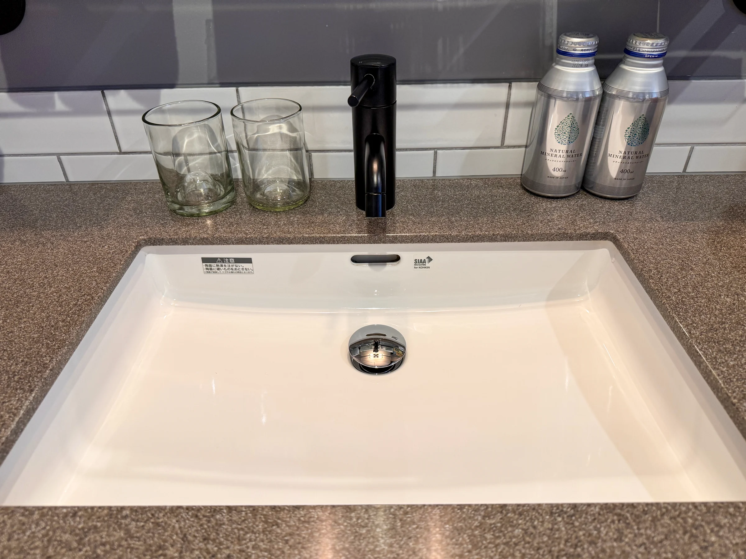Glasses and bottled water at the washbasin