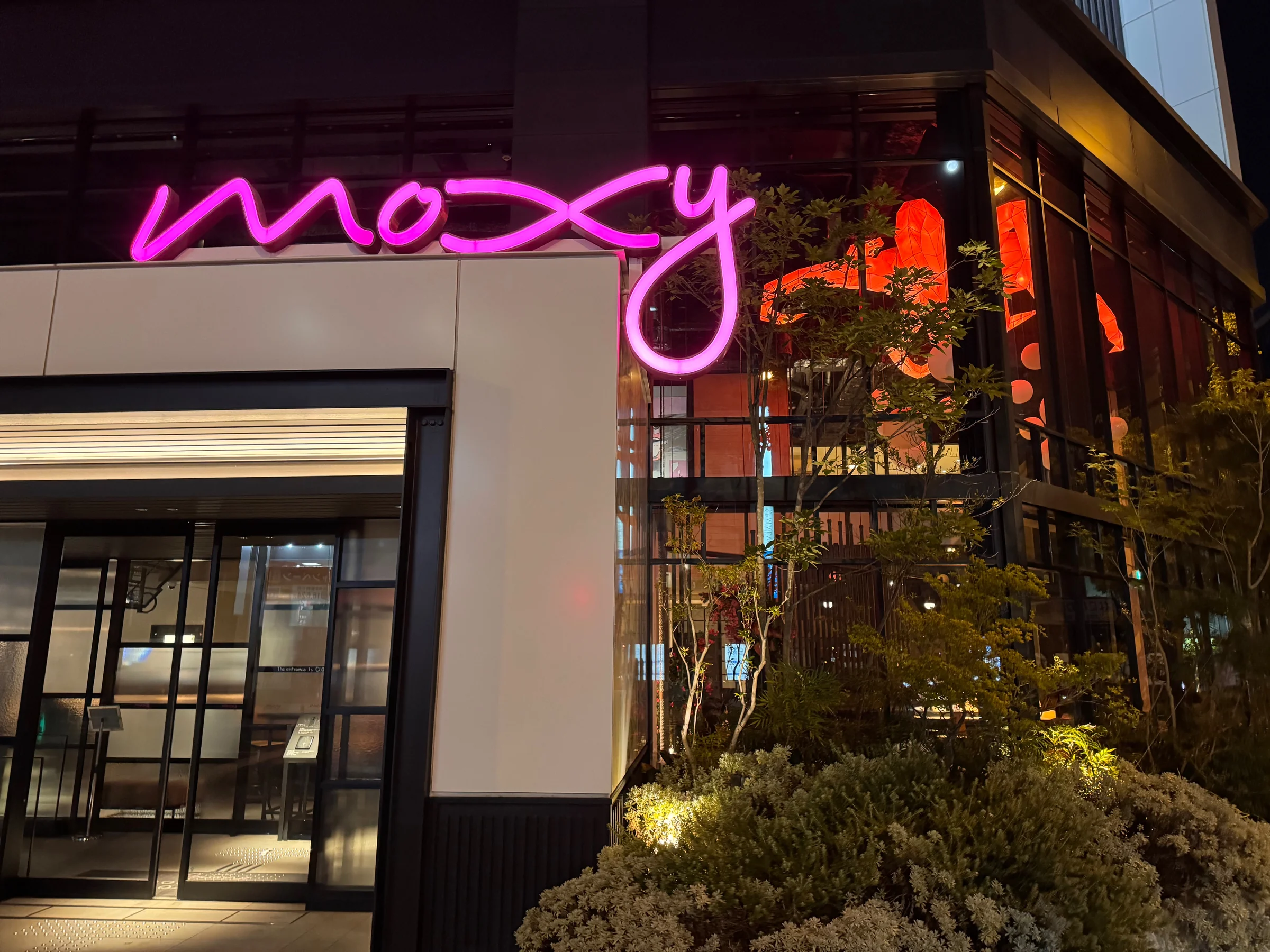 The pink logo at the entrance at night