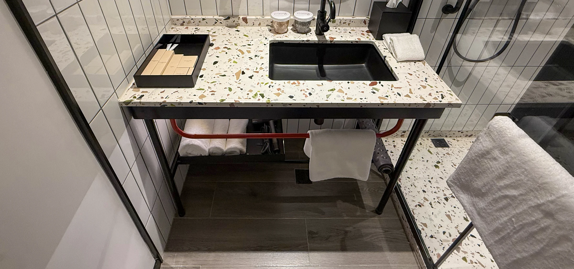 The terrazzo-patterned counter and black washbasin.