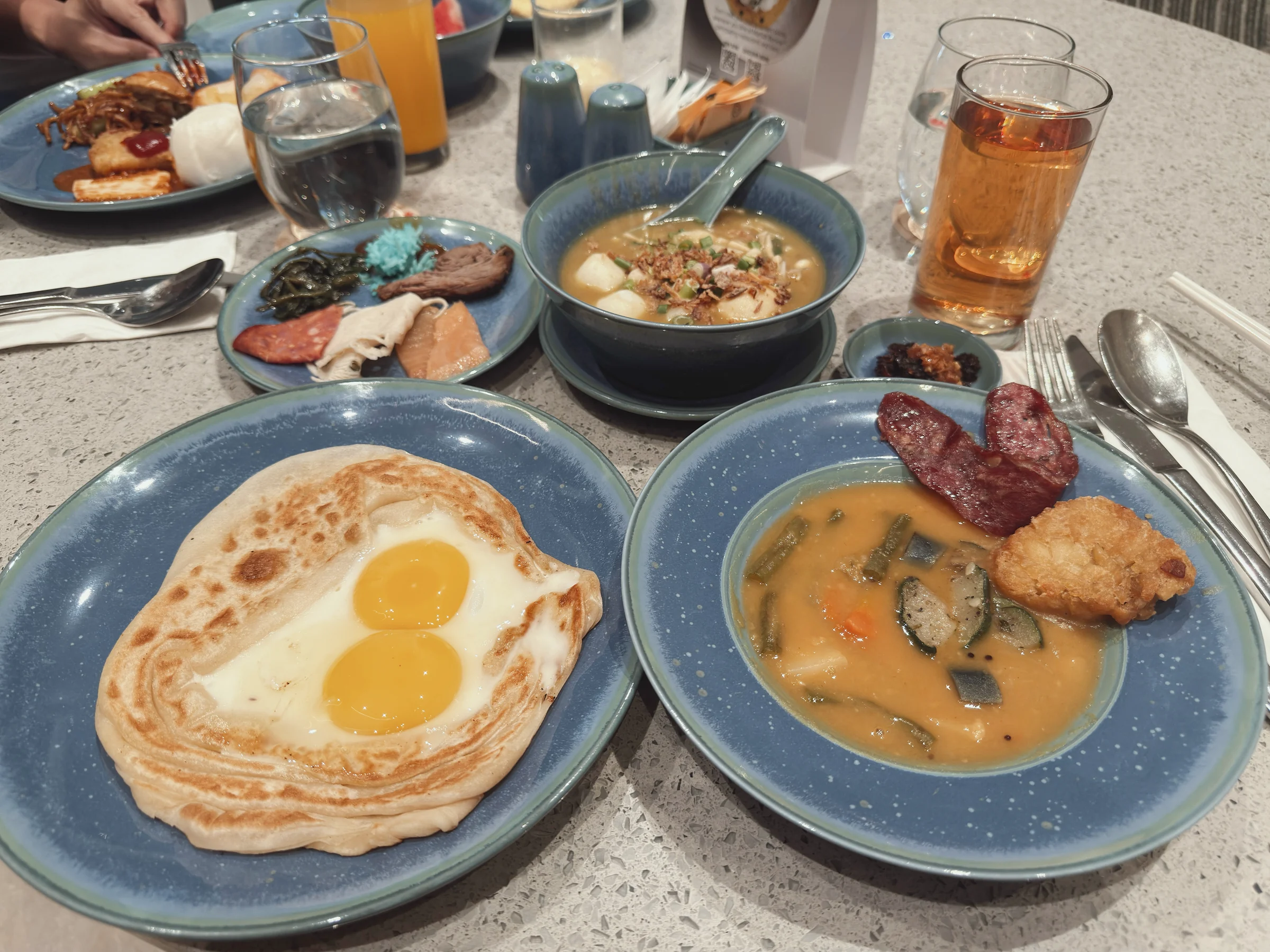 ロティにのせた目玉焼きとオムレツ。