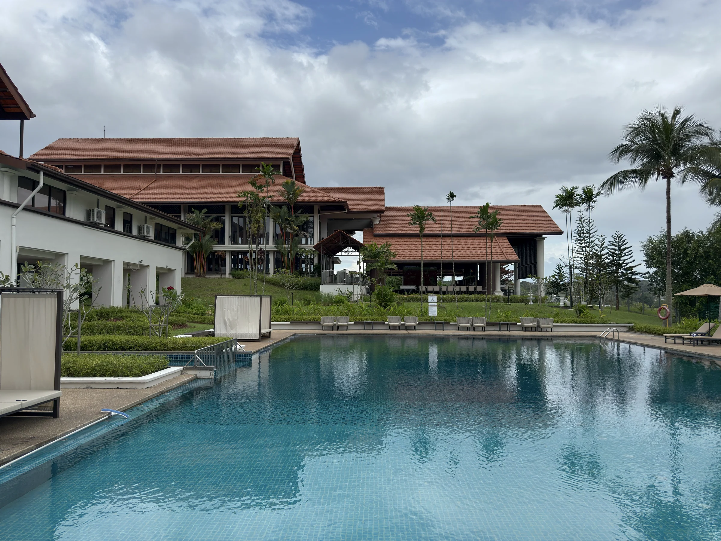 Palm Garden Hotelの赤い屋根の建物と屋外プール