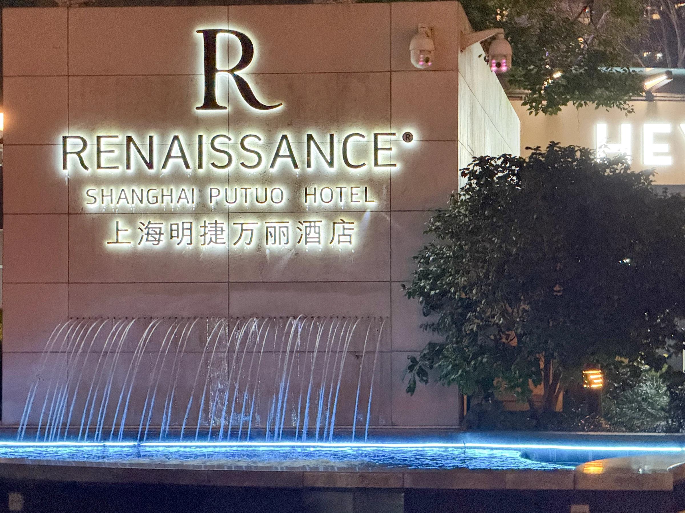 The hotel sign and a wall with flowing water.