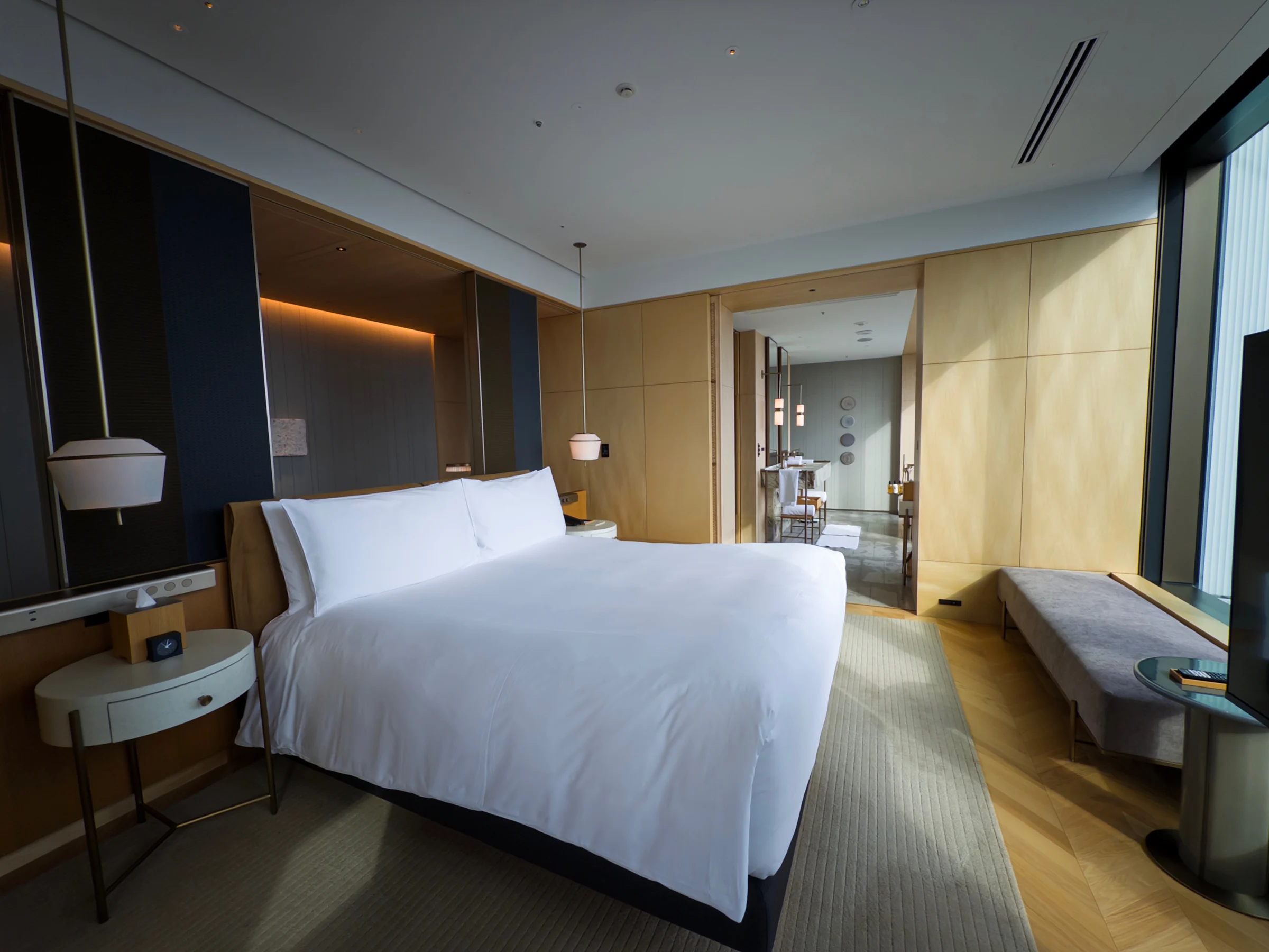 The bedroom, with white bedding and a window