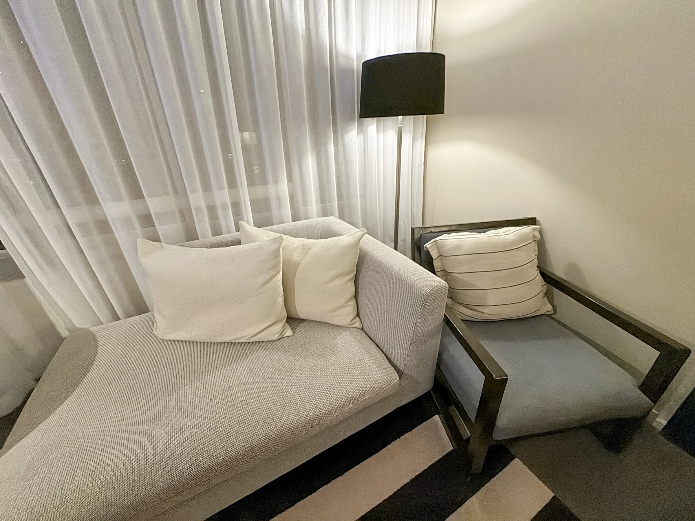 The sofa by the window and striped carpet.