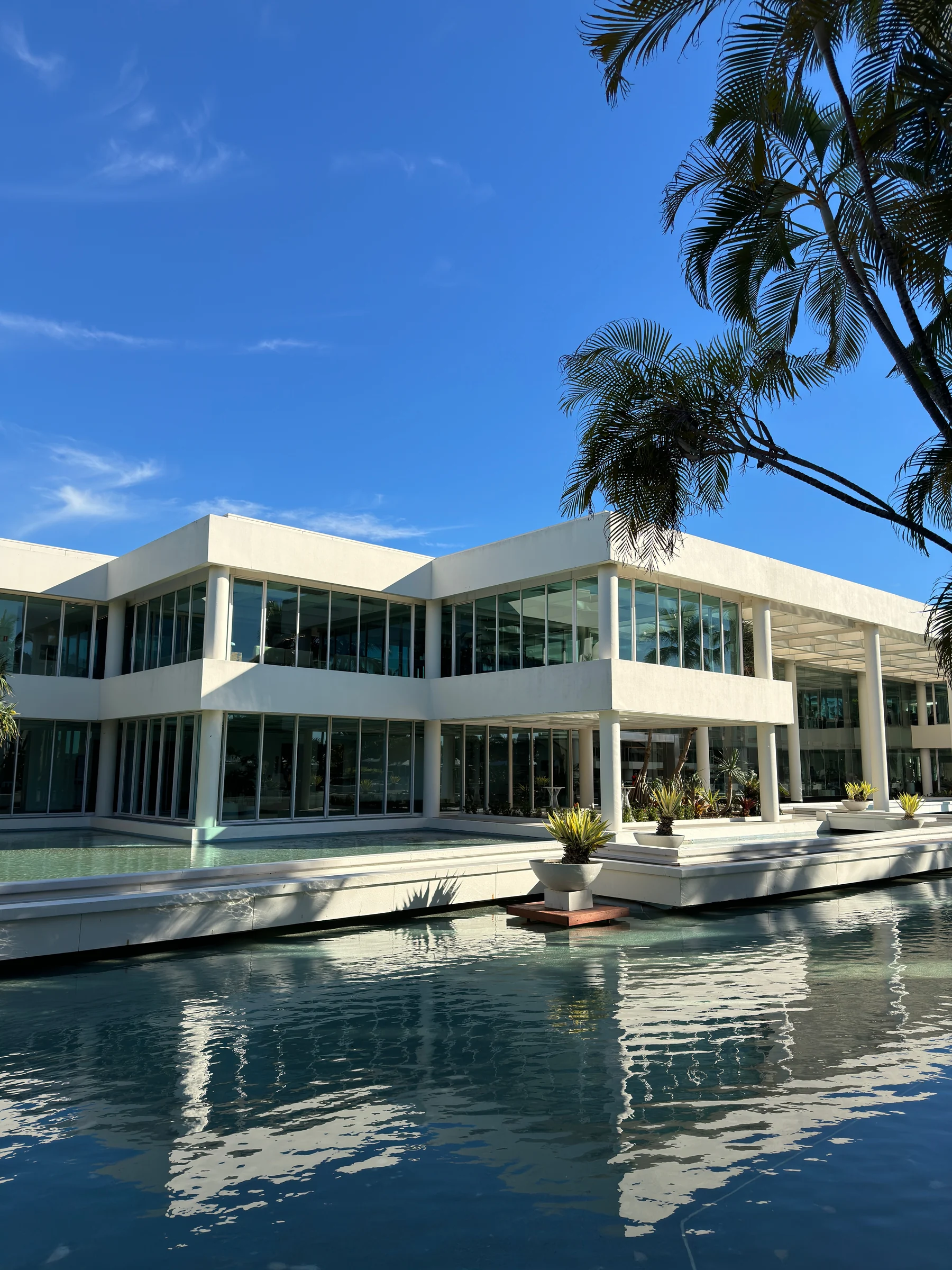 White buildings reflected in the pool under blue sky.