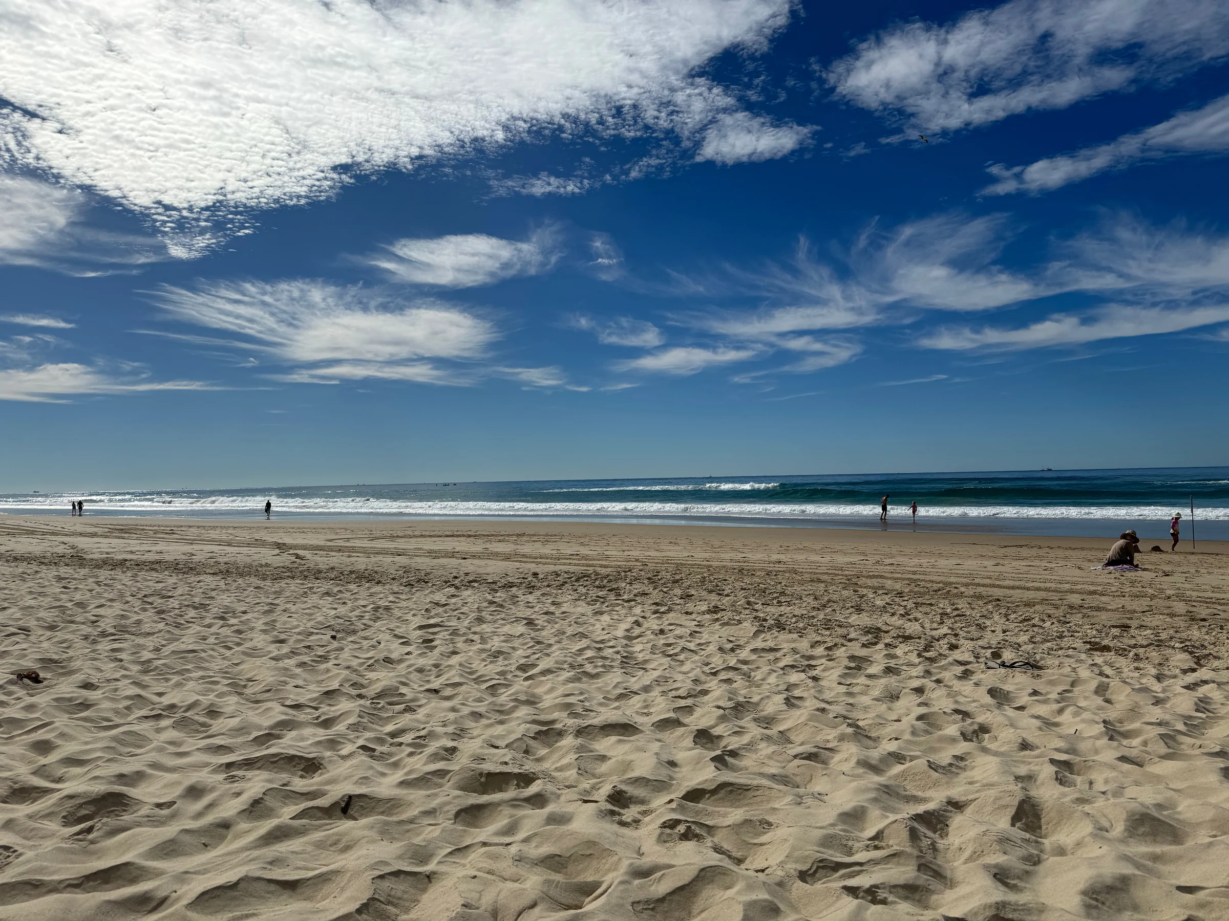 The wide sandy beach and blue sky.
