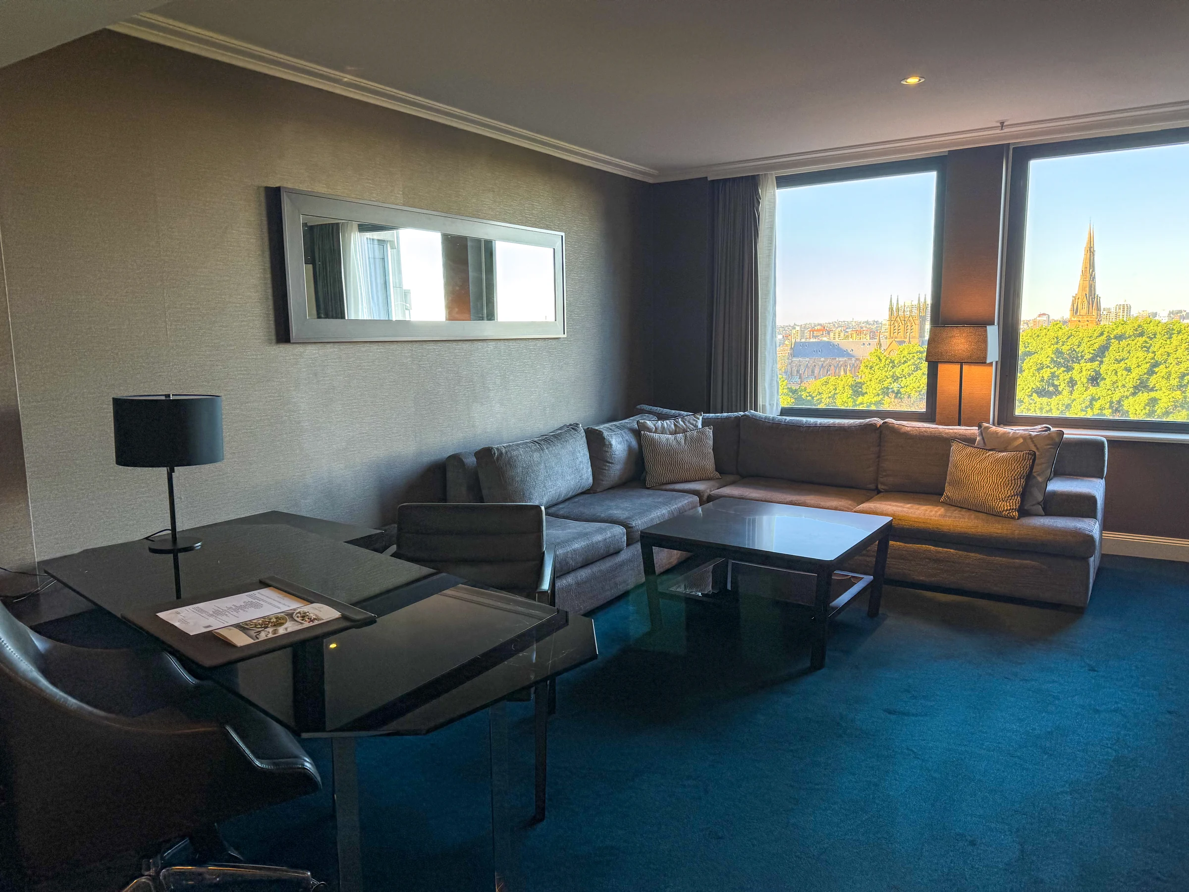 The Executive Suite living room overlooking Hyde Park's greenery and St Mary's Cathedral