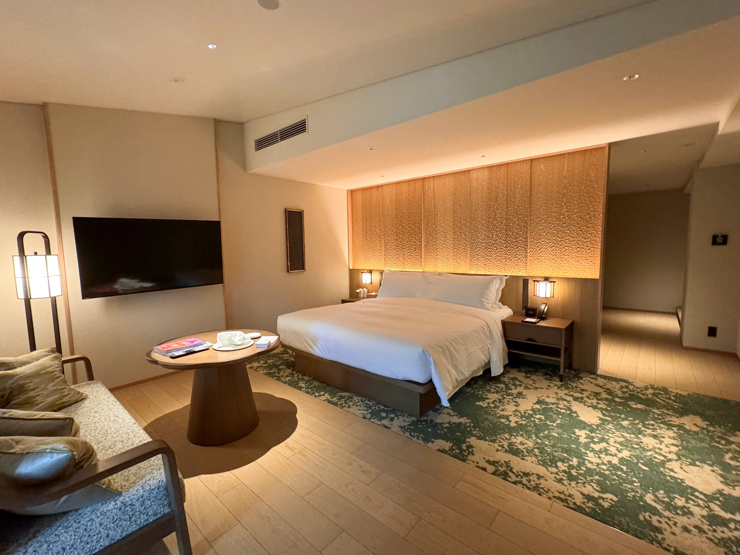 An onsen king room at Shisui Nara, with wood interiors, soft lighting, a sofa and a king bed
