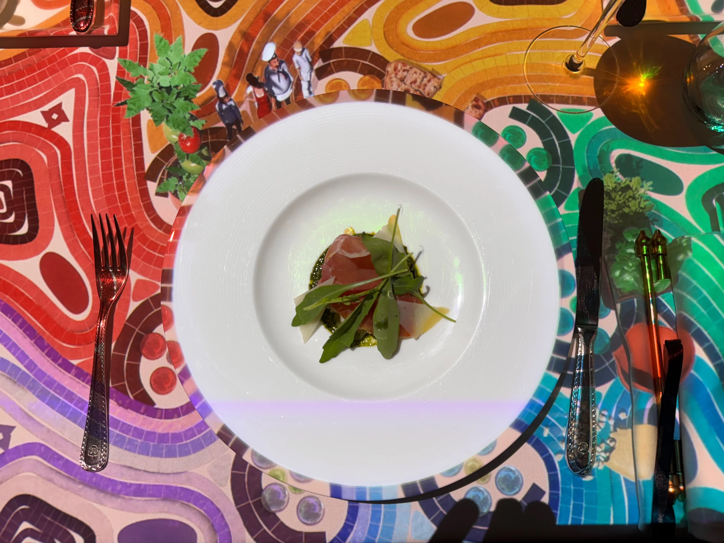 An appetiser alongside colourful projections.
