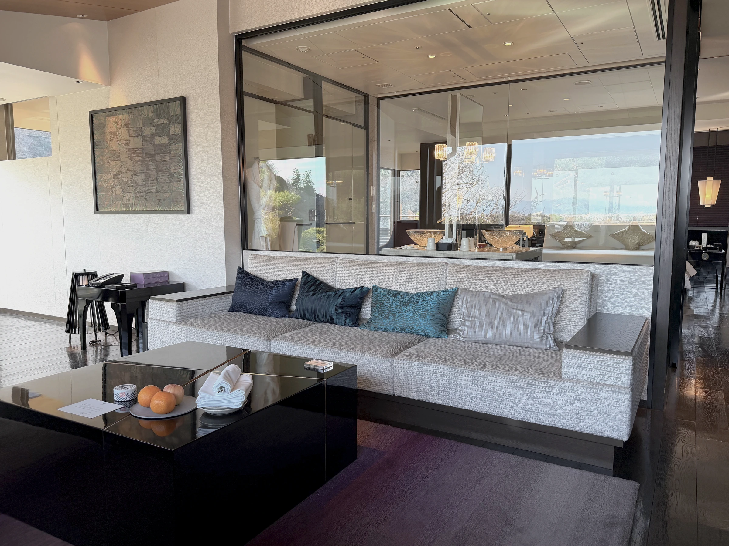 The Presidential Suite’s living area with jade-green cushions and surrounding windows