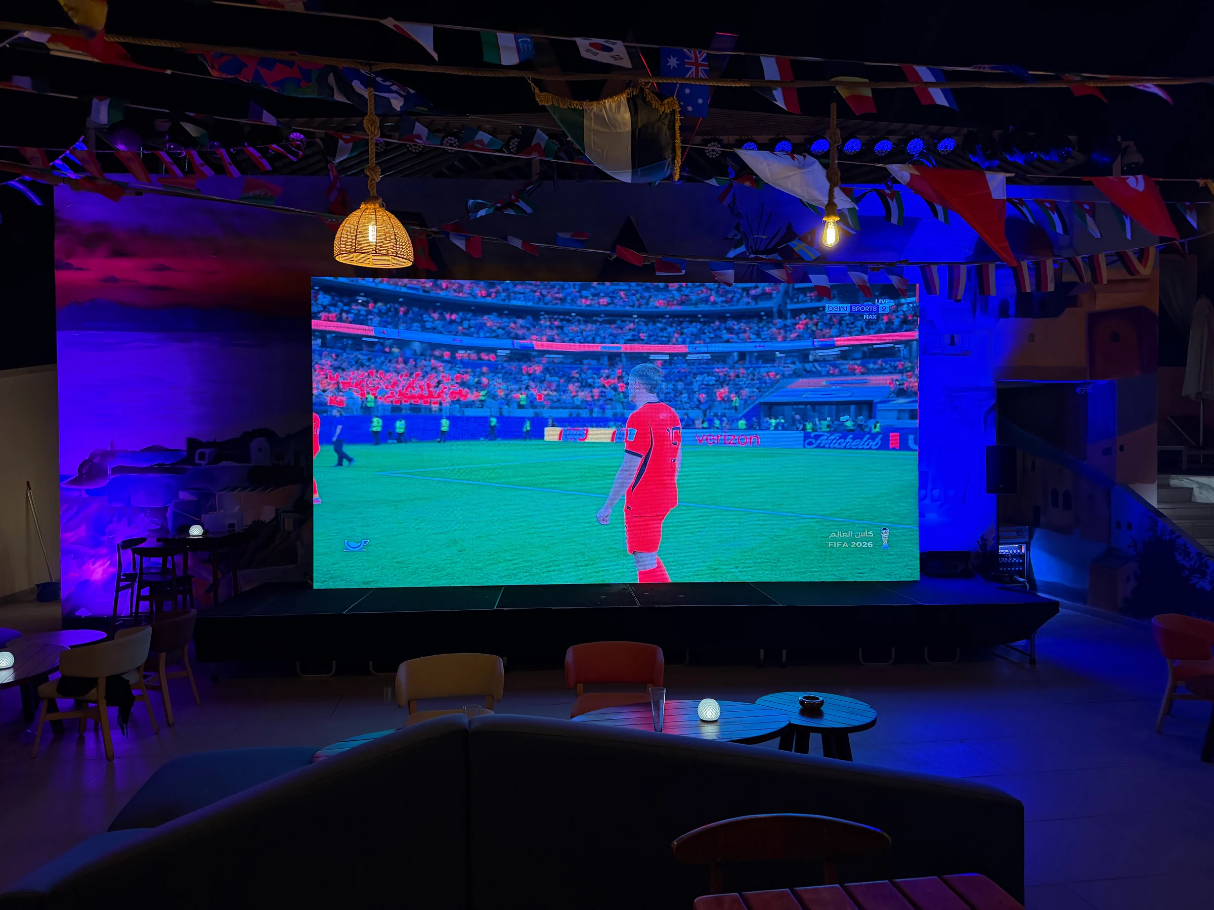 夜の屋外バーで映し出されたサッカーの試合