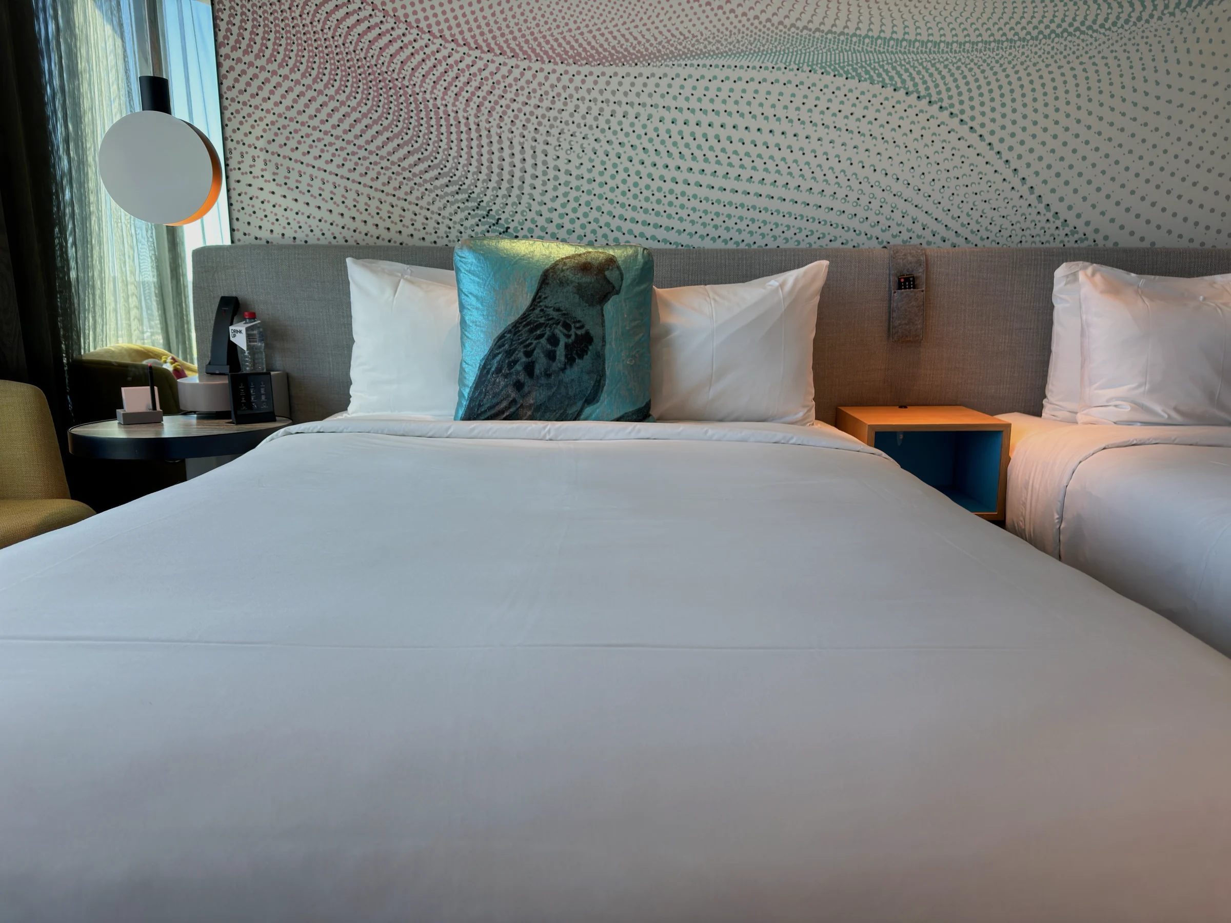 White bedding and bird-patterned cushions.