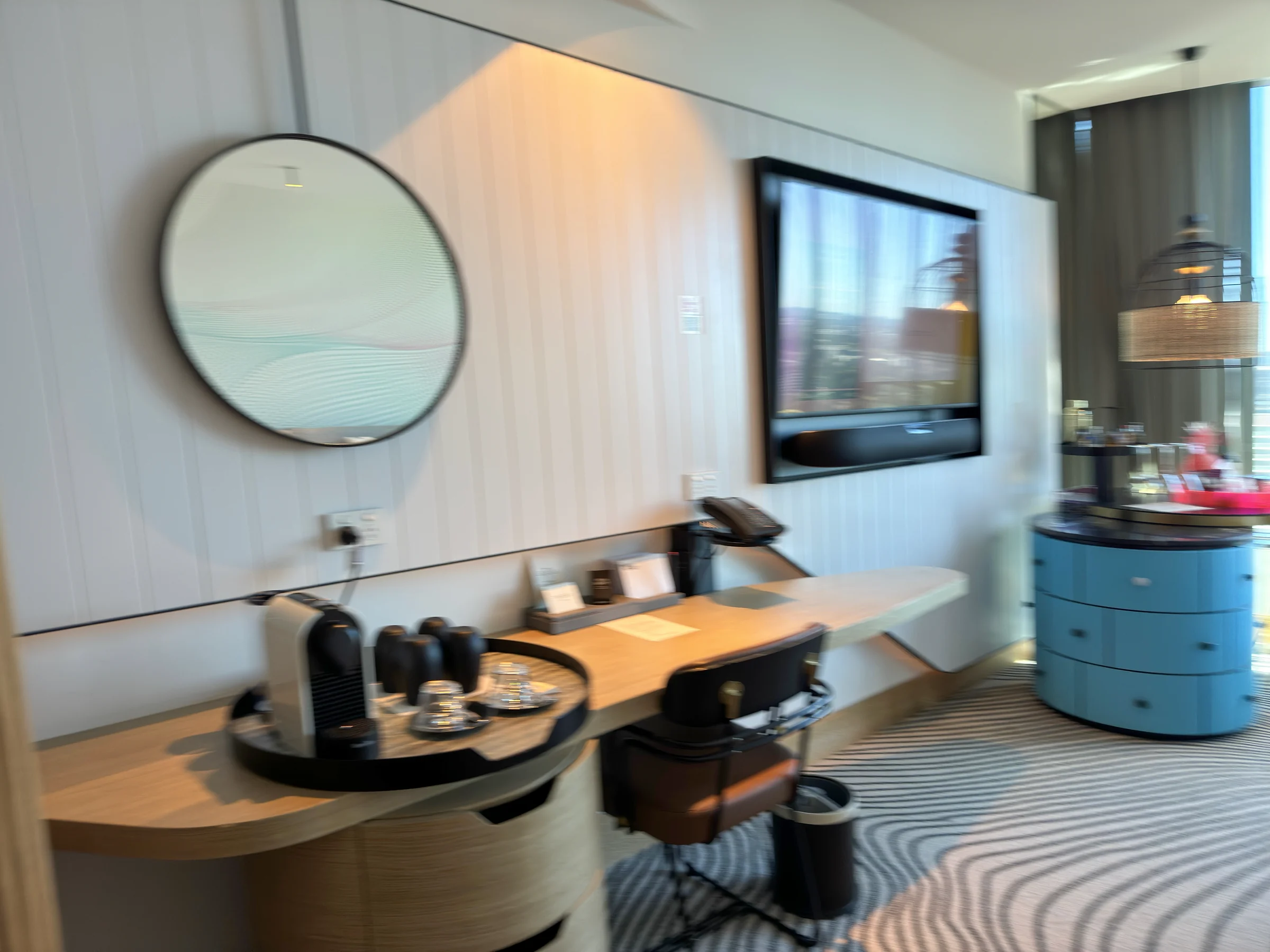 The TV, desk and blue drawers.