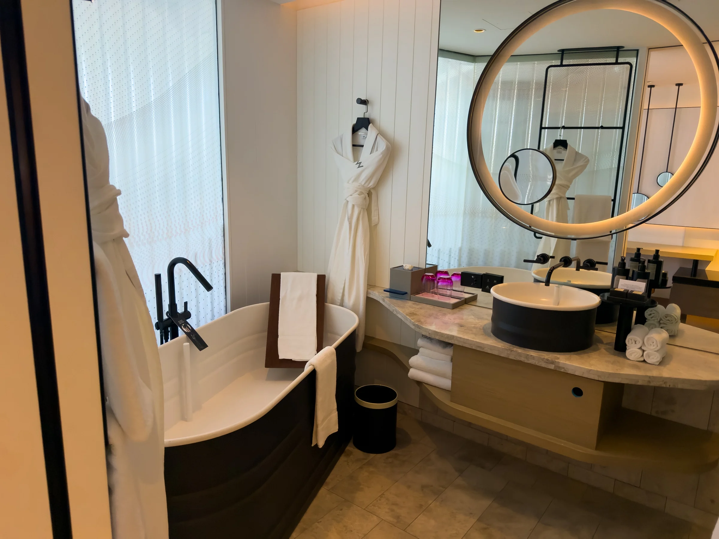 Round mirrors and a black washbasin.