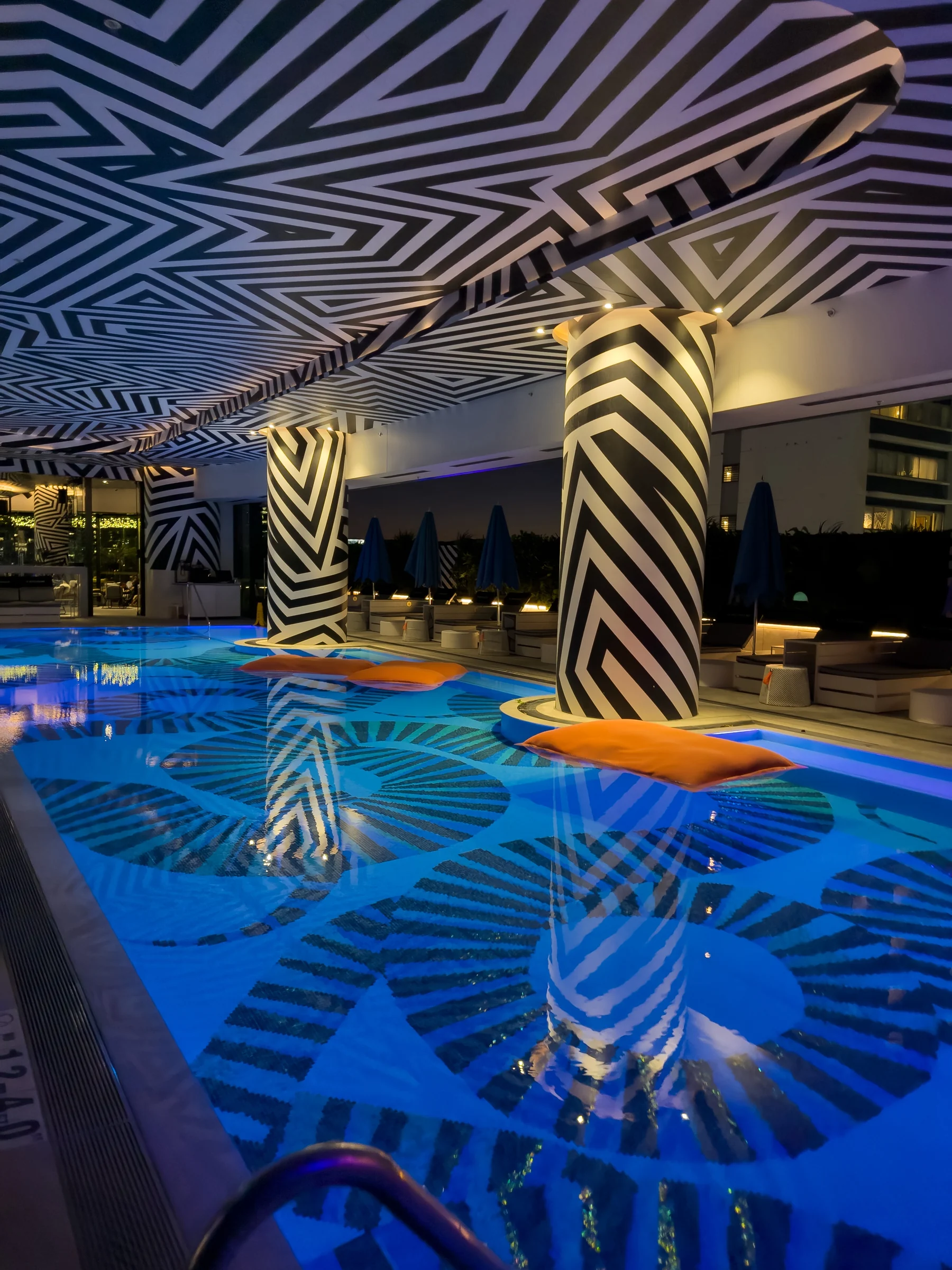 The pool with blue water and black-and-white patterns.